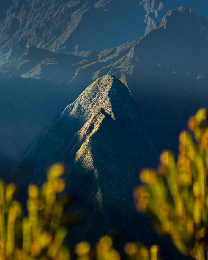 Scenic view of a pointed peak amid lush slopes in La Réunion.