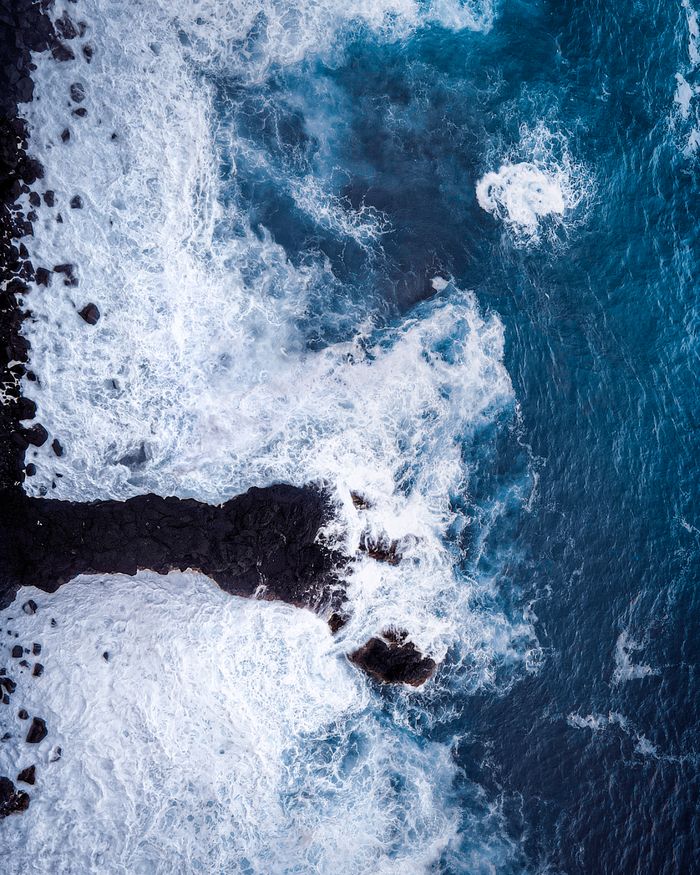 Stunning aerial shot of waves crashing on rocks at the shore of Saint-Pierre, Réunion.